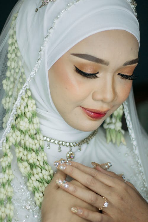 Photo of a Bride in a White Hijab and a Glamour Makeup Look 