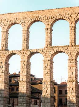Historic Roman aqueduct with elegant stone arches in Segovia, Spain, captured in warm evening light.