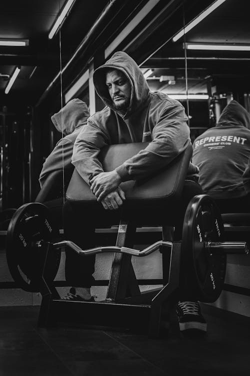 A Man in a Hoodie Sitting at the Gym 