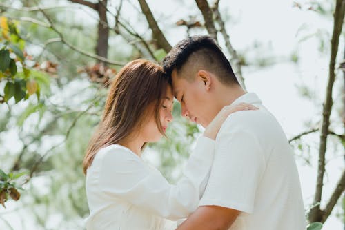 A Young Couple Standing Head to Head with Eyes Closed