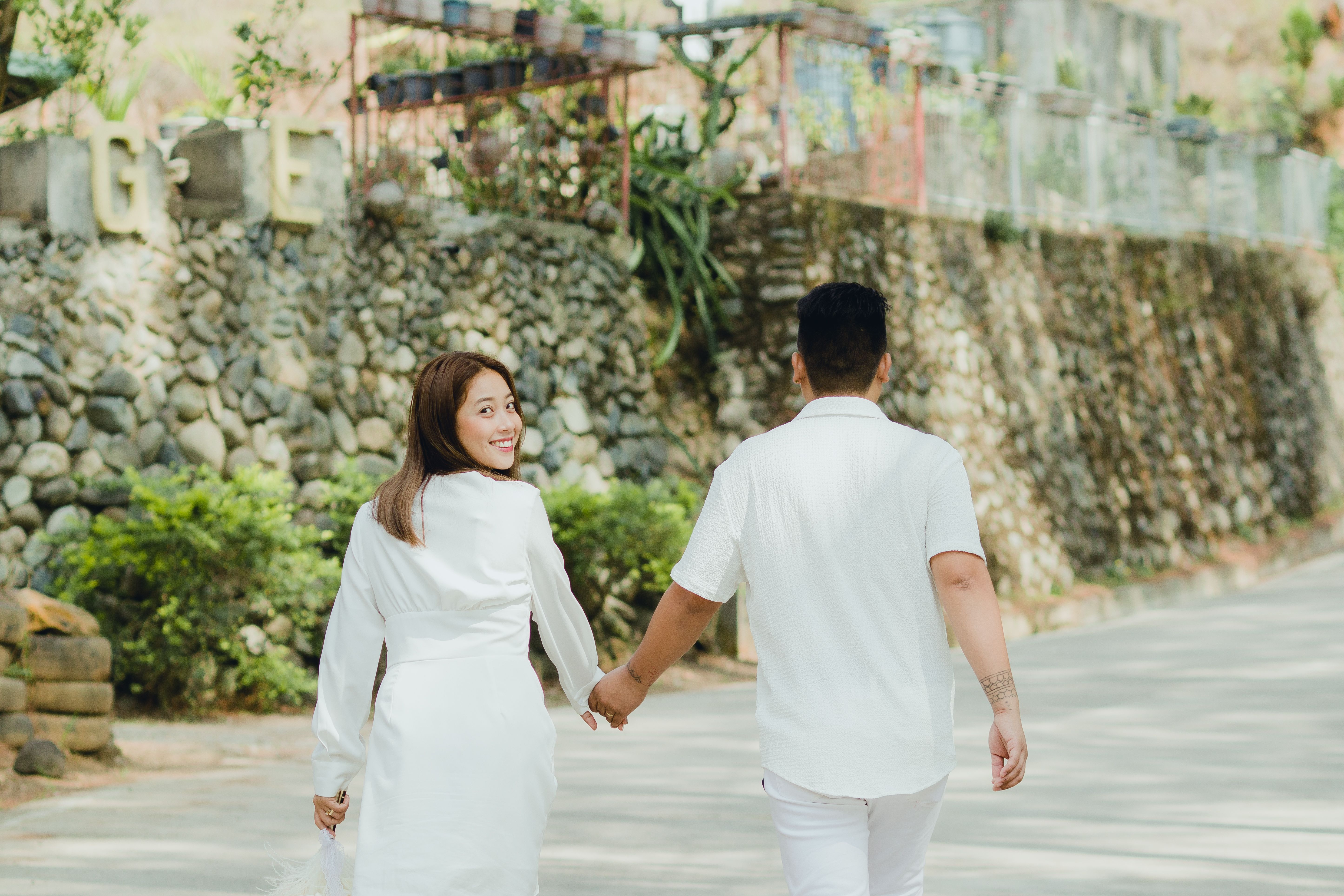 Back View of a Couple Holding Hands while Walking on a Pavement · Free ...