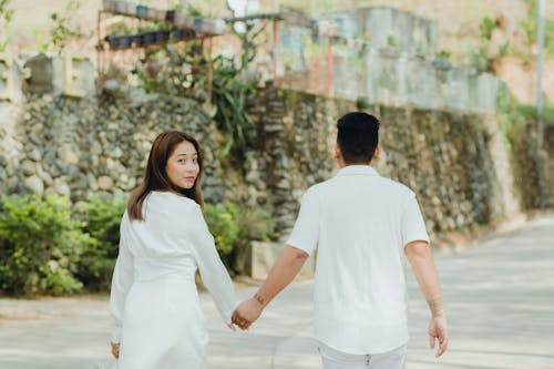 Loving Couple Holding Hands and Walking on Pavement
