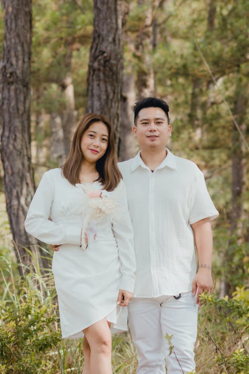 Happy Couple in White Clothing Posing in Park