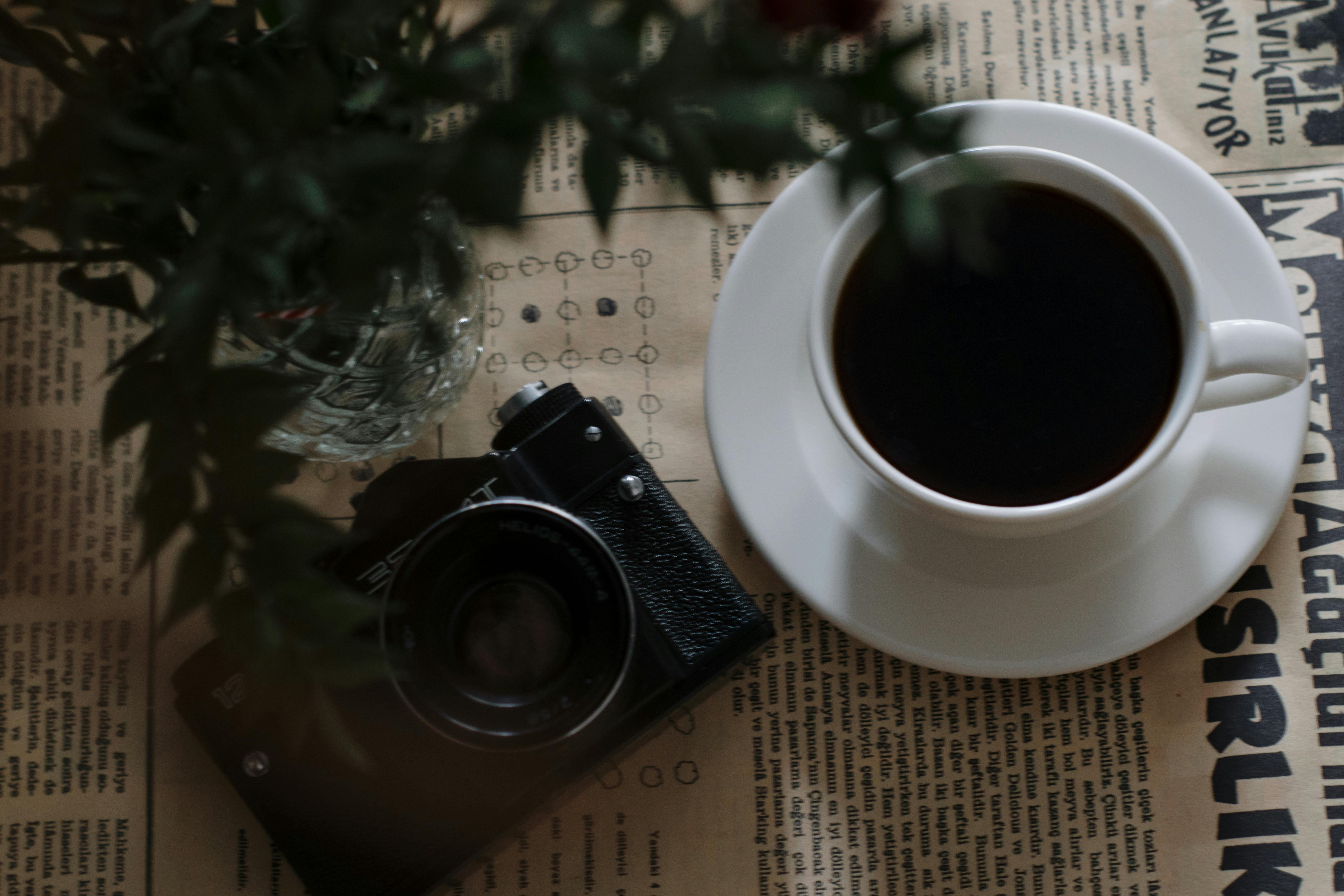 Free A cup of coffee and a camera on a newspaper Stock Photo