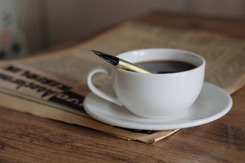 Coffee Cup on Newspaper on Table