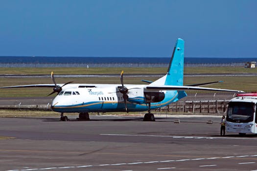 A twin-engine turboprop airplane on a runway with a clear horizon in the background.