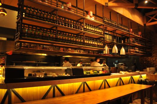 Luxurious restaurant interior featuring chefs at work in a warm, inviting atmosphere.