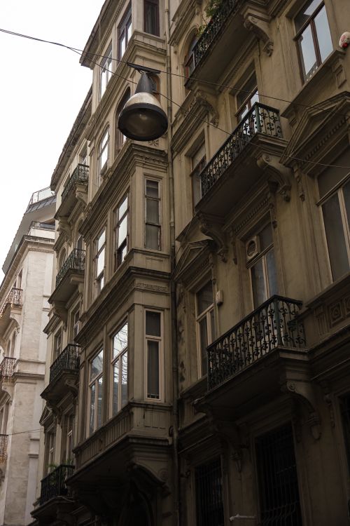 Free Low angle view of a historic apartment building with balconies and ornate facade details. Stock Photo