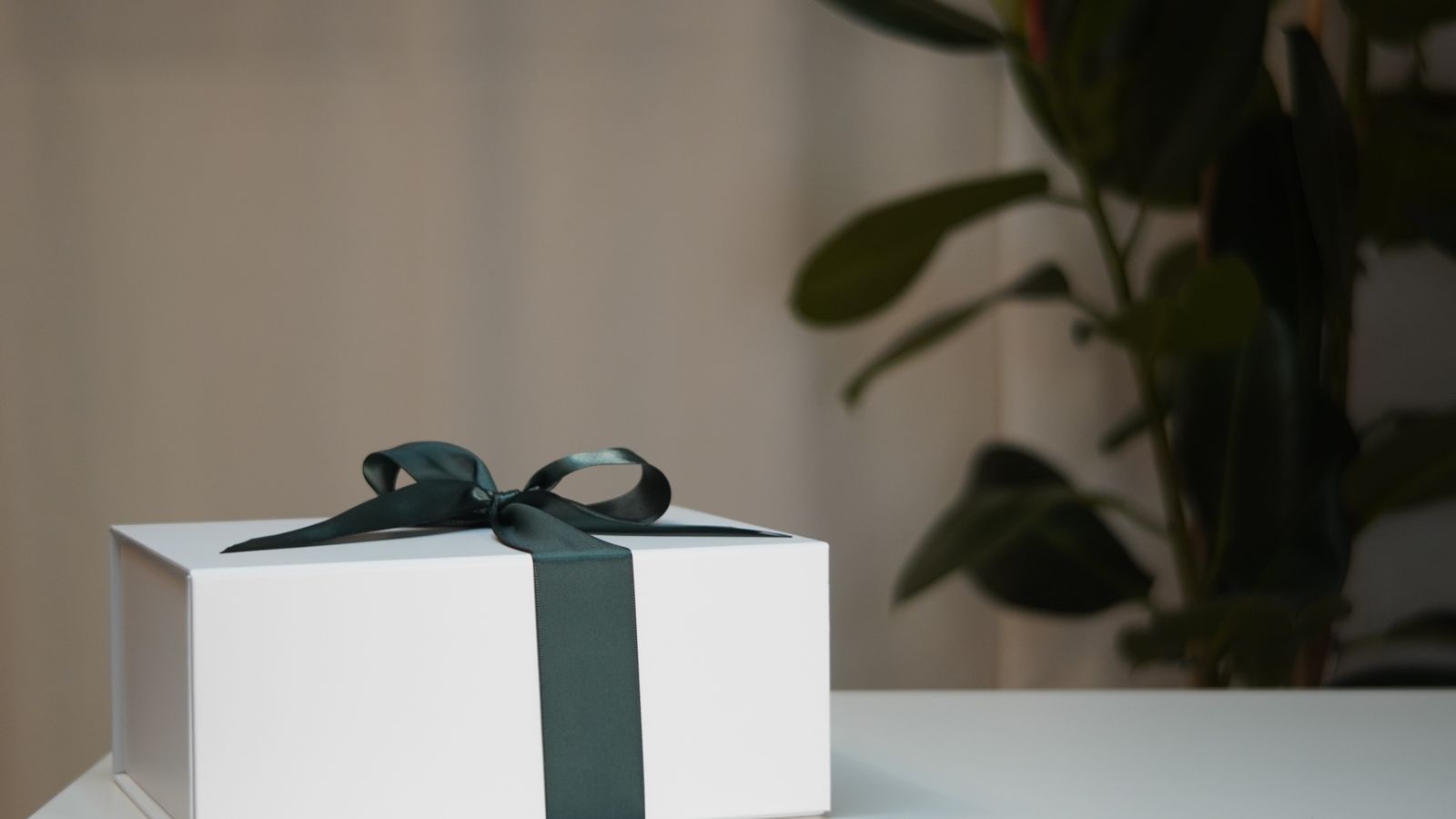 White gift box tied with a dark ribbon on a table
