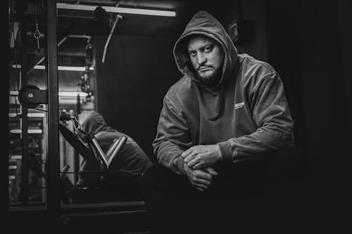 A Man in a Hoodie Sitting at the Gym 