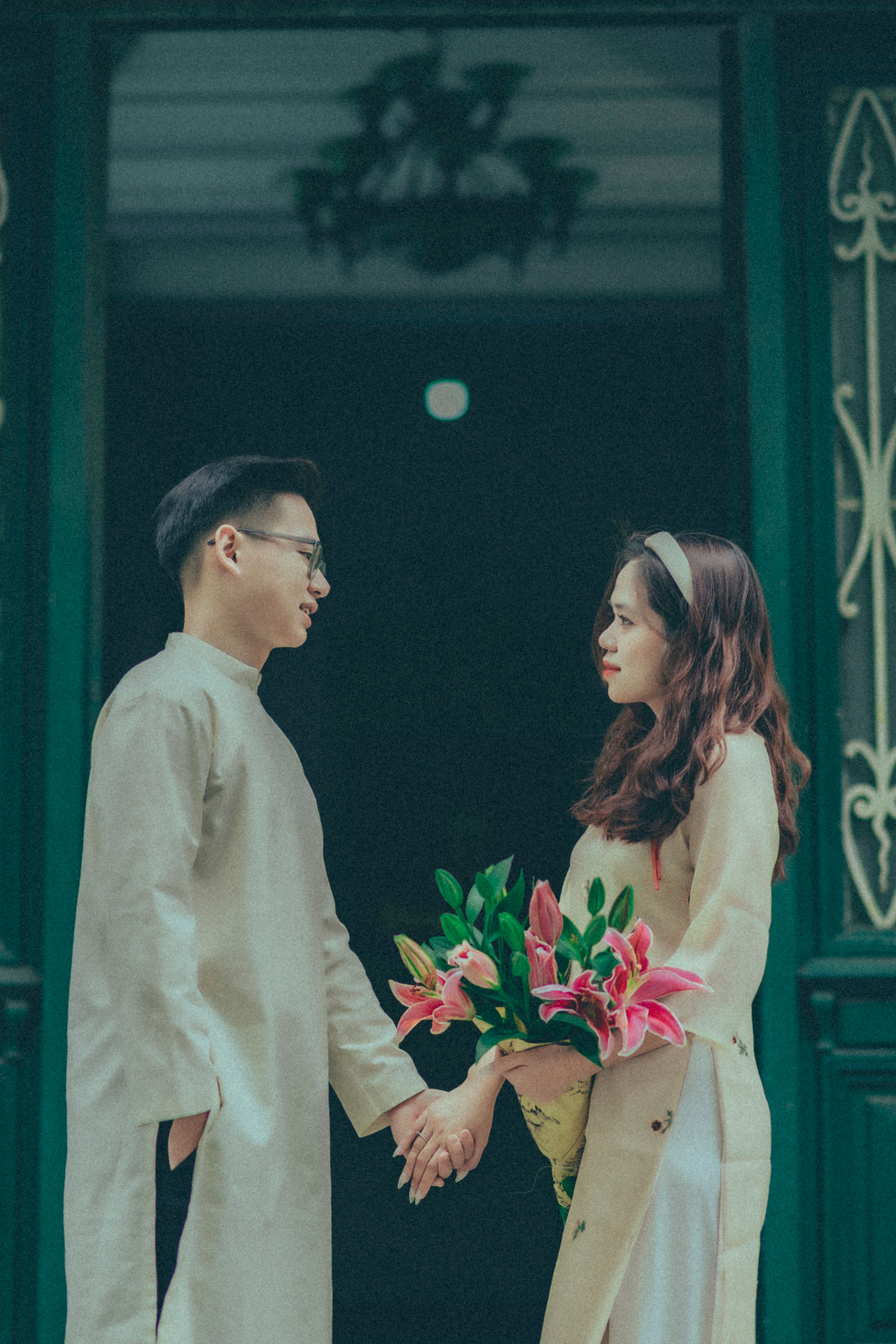 A Couple in Traditional Clothing Holding Hands and Looking at Each ...