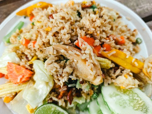 Cooked Rice with Chicken and Vegetables on a White Plate