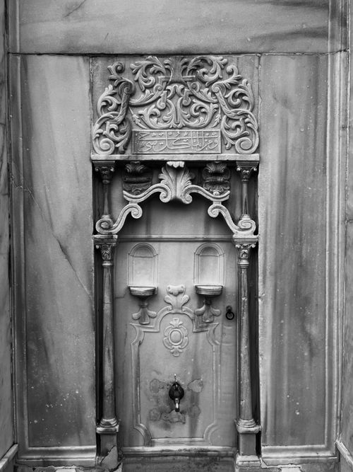 Free Intricate black and white stone fountain with ornamental carvings and decorative reliefs. Stock Photo