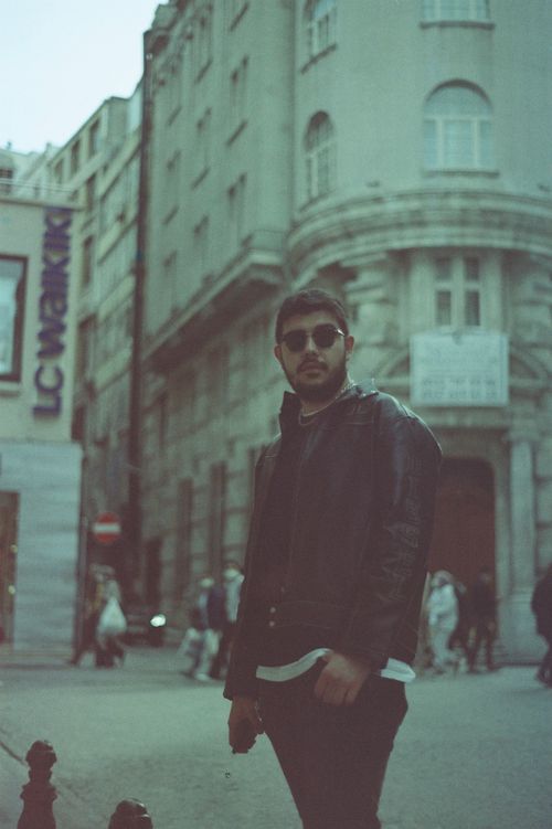 Free A stylish man in sunglasses stands on a bustling Istanbul street with historic architecture. Stock Photo