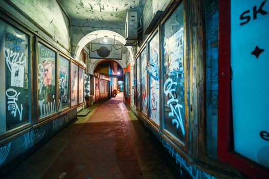 Urban graffiti alley in Poznań, Poland. Narrow path with artistic walls and vibrant colors.