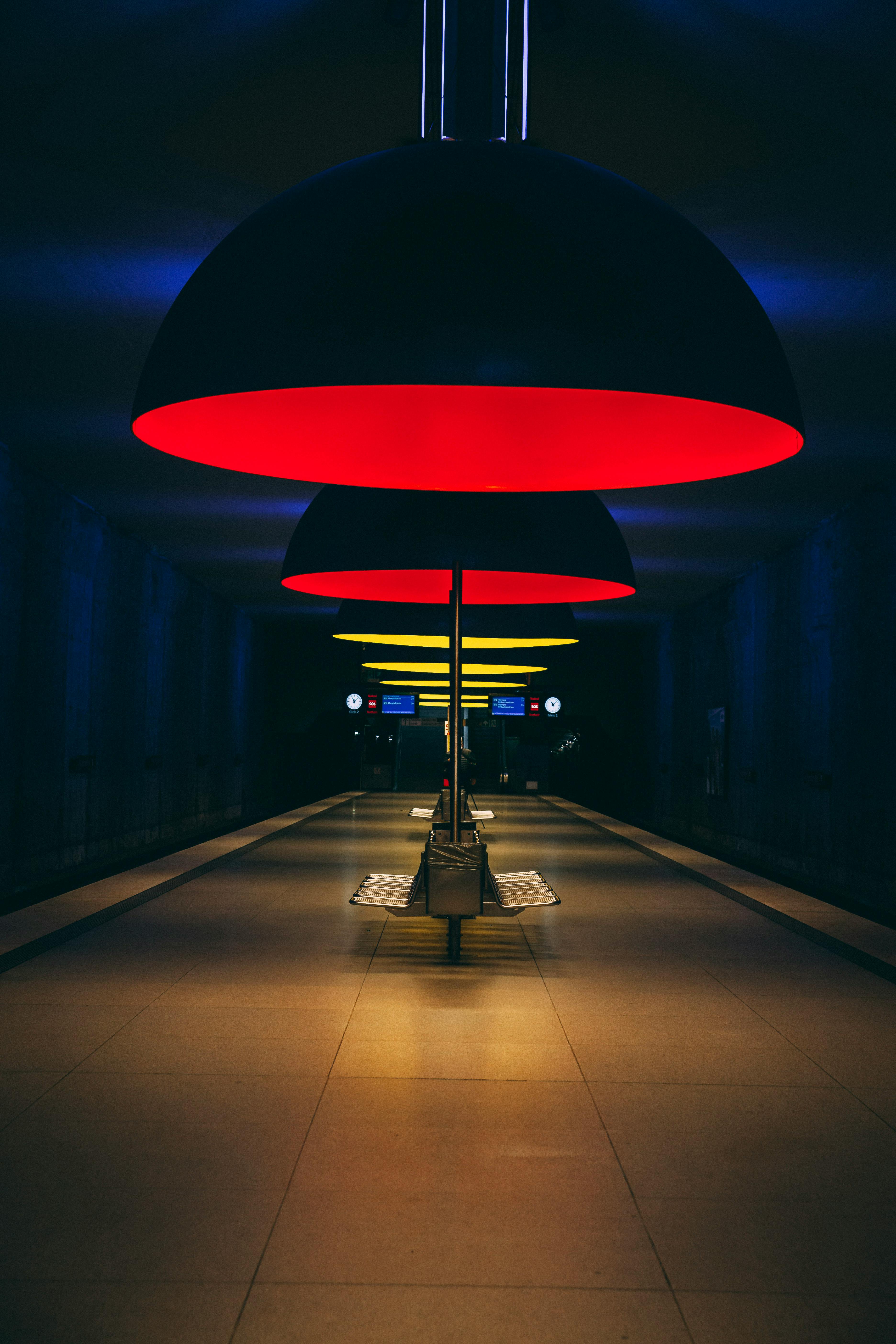 A modern subway station lit by colorful, distinctive dome lamps creating an urban ambiance.
