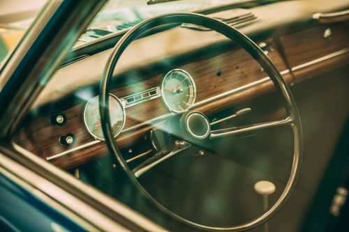 Free Close-up of a vintage car dashboard with a classic steering wheel. Stock Photo