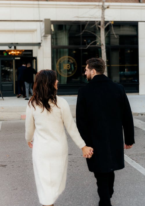 Back View of Couple in Coats Walking and Holding Hands