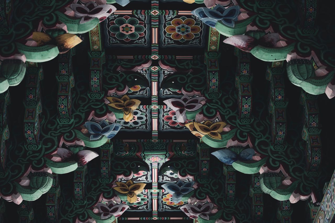 a vibrant detailed carved and painted wooden ceiling with floral desig