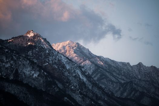Serene snow-covered mountains under a vibrant sunset sky.