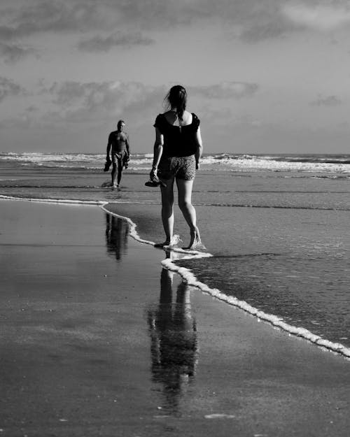 Candid Shot of Two People Walking on a Beach 