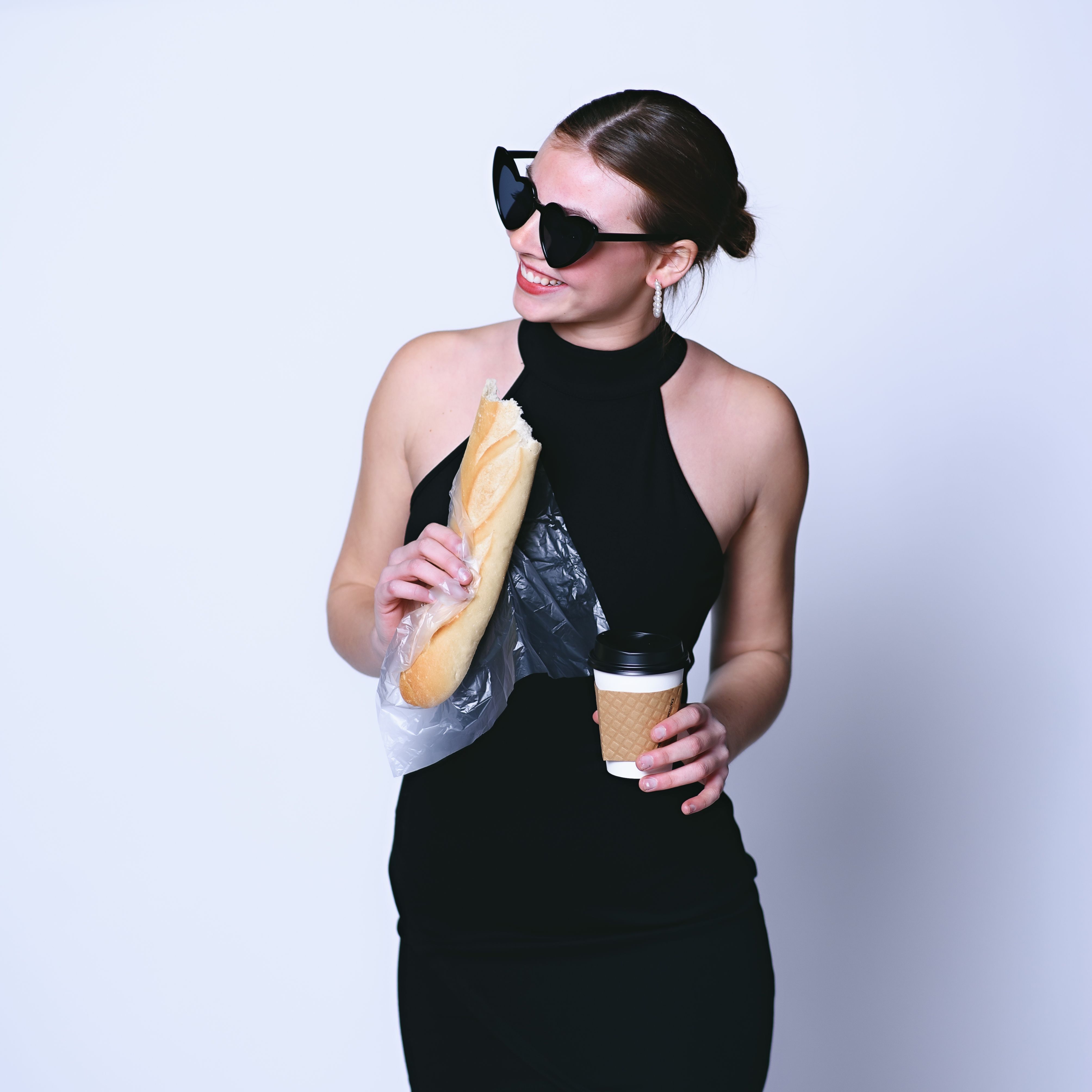 Woman carrying a baguette and coffee — photo by Jessica Pope on Pexels