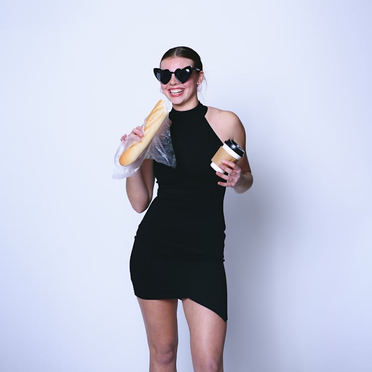 Smiling Woman In Sunglasses And Black Dress Standing With Food