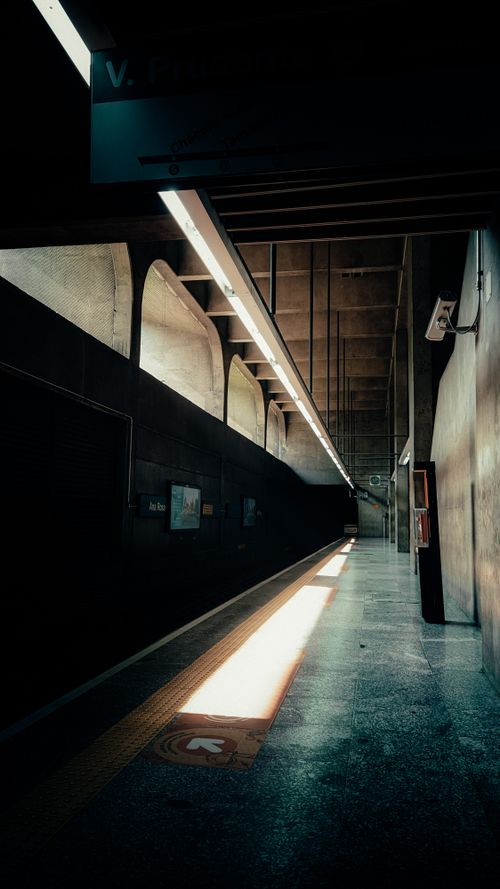 Free A moody sunlit subway platform showcasing architecture and shadows in an urban setting. Stock Photo