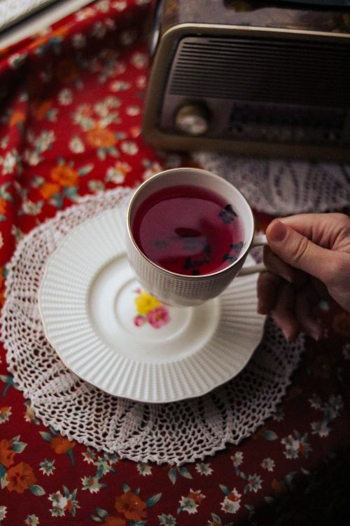 Free A cozy setup of a floral tea cup on a saucer with a classic radio in the background. Stock Photo