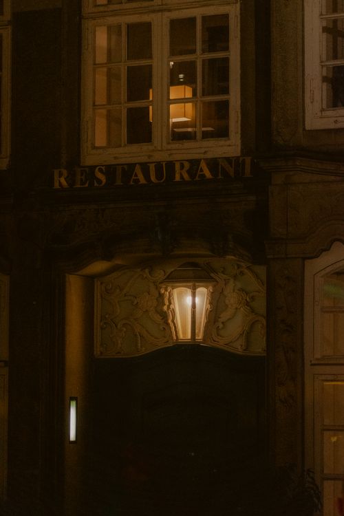 Free Mysterious restaurant entrance at night with glowing windows and ambient lighting. Stock Photo