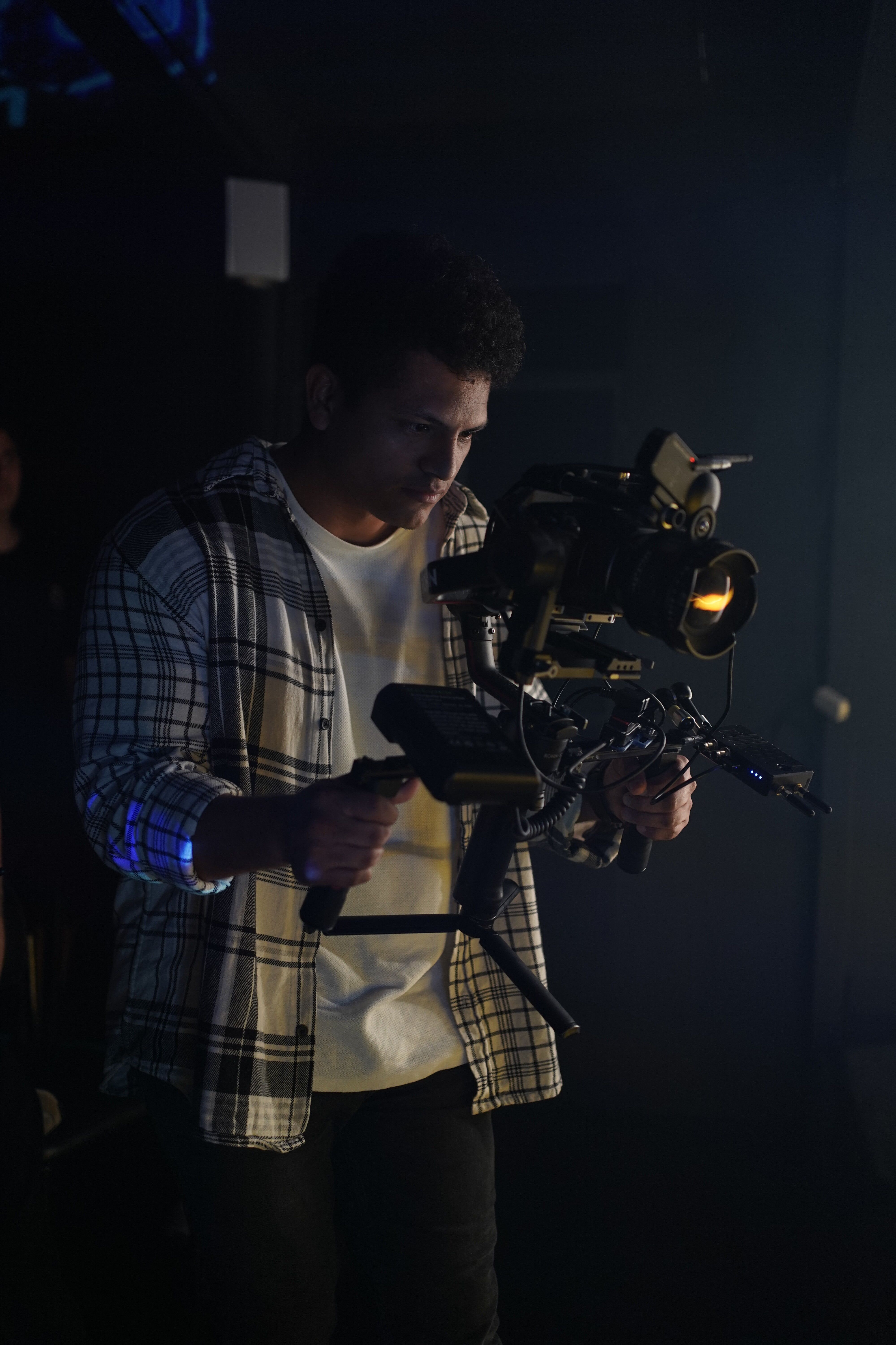 Cameraman working with video rig during a studio shoot.
