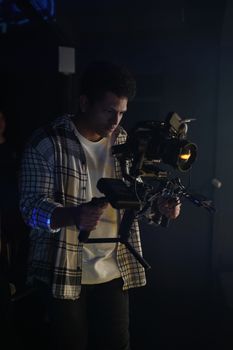 Cameraman working with video rig during a studio shoot.