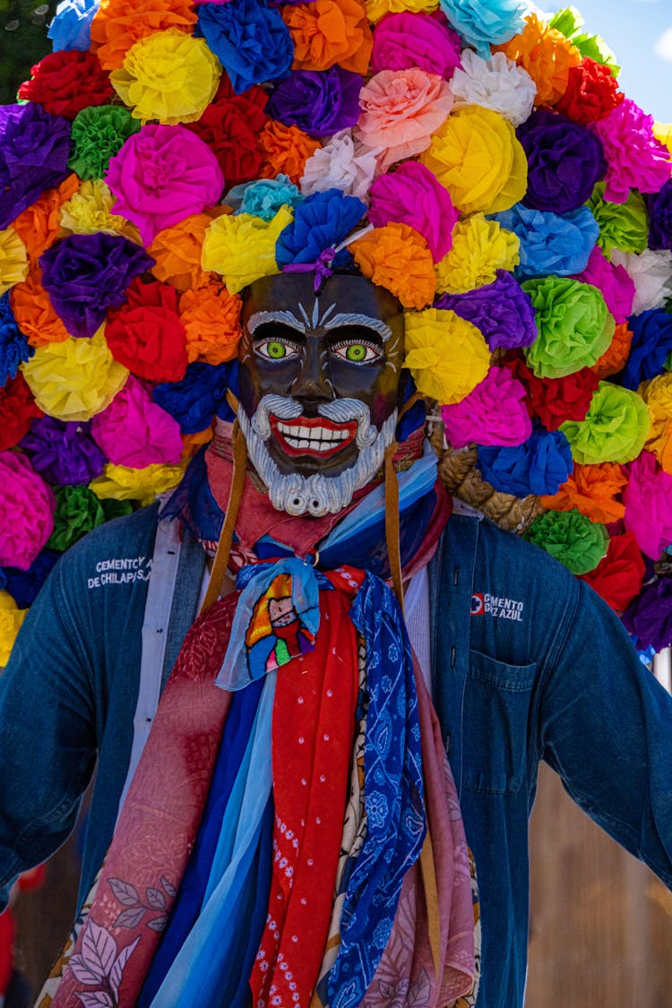 Man Wearing A Mask And Large Flower Headdress