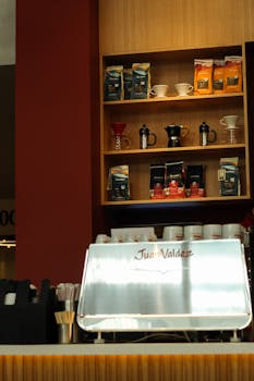 A coffee counter in a café with coffee bags and brewing items on shelves.