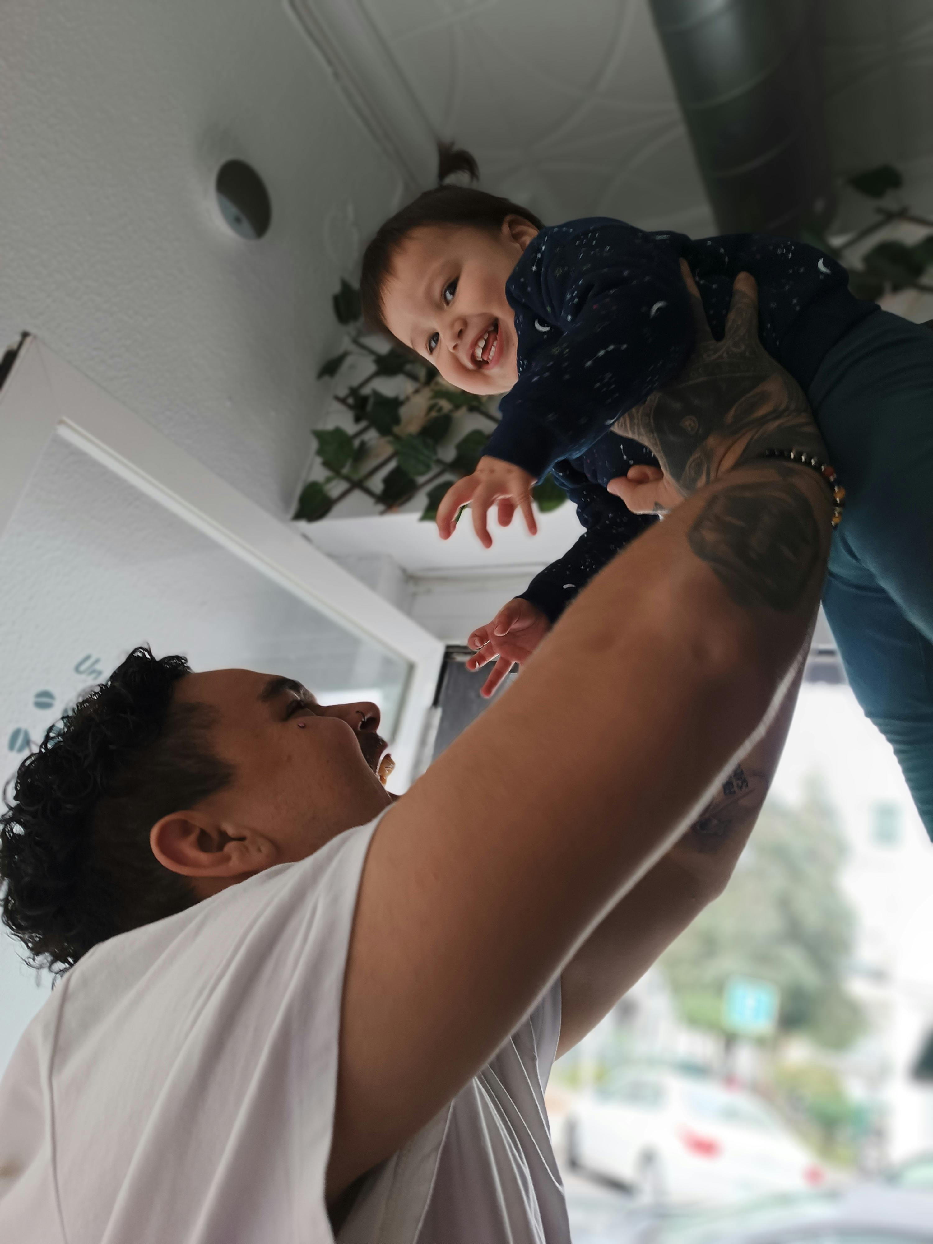 man holding child up in the air