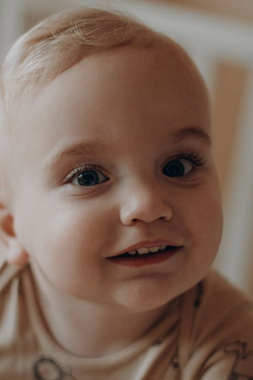 Portrait of a Smiling Blonde Baby with Blue Eyes