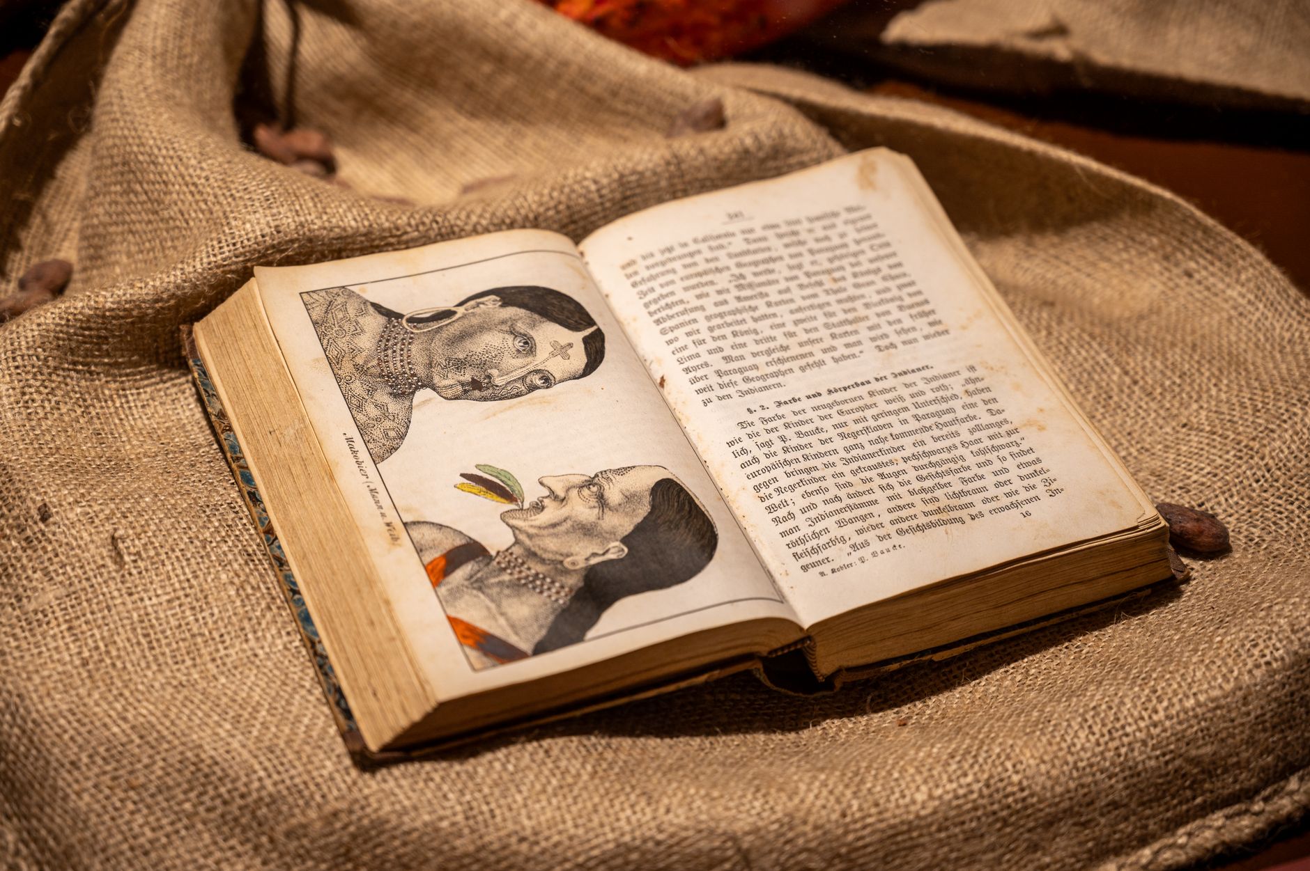 Clifford Geertz’s anthropology book beside Balinese cockfight photographs on a wooden research desk