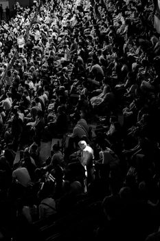 High-contrast, black and white photo of a large crowd at an indoor event in Ankara.