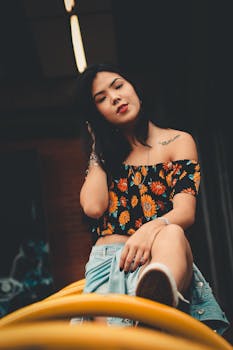 一位纹身的时尚女性穿着花卉上衣和牛仔短裤在户外摆姿势