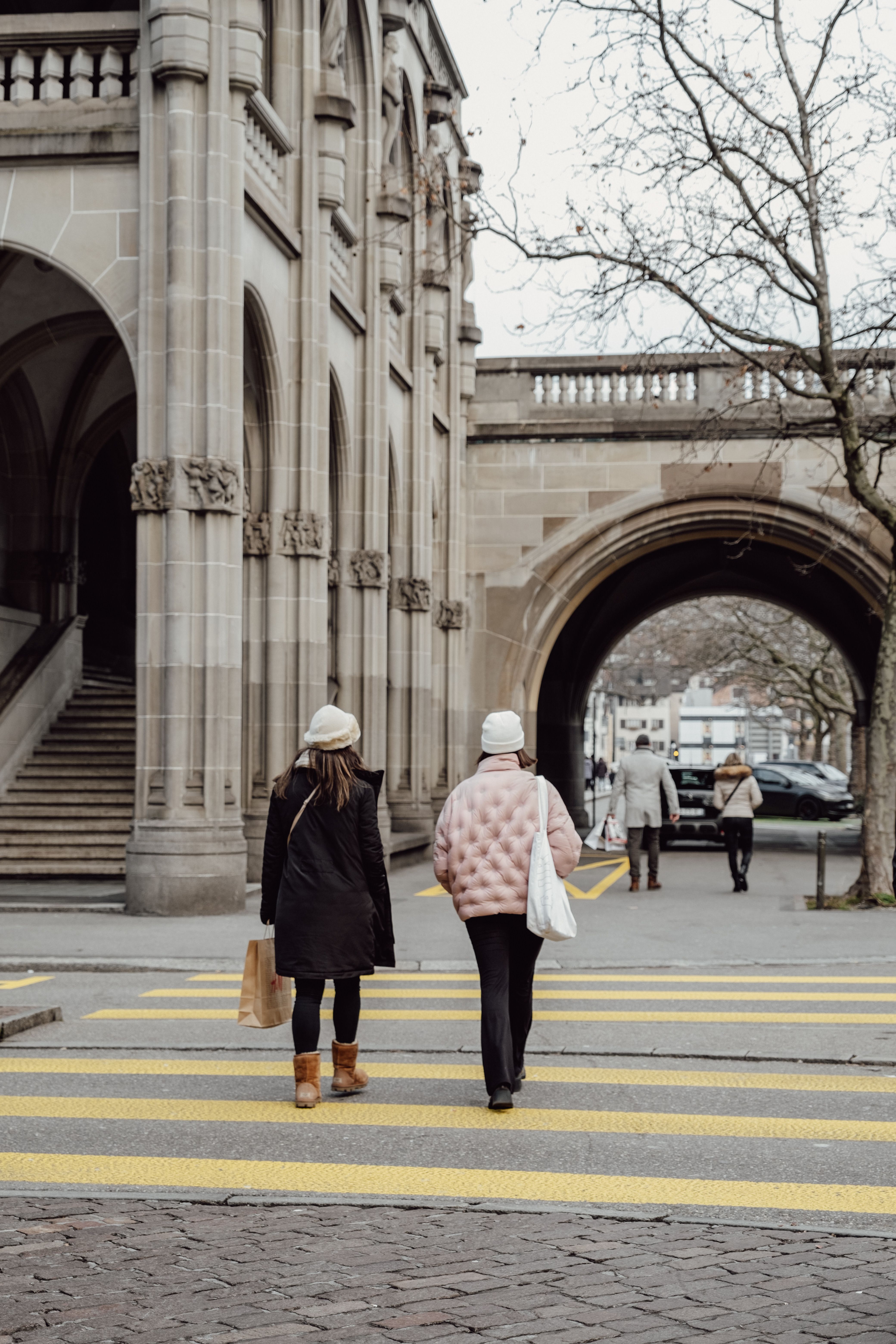Two people walking across a crosswalk in front of a building · Free ...