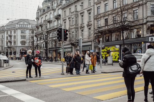Free Pedestrians wait at a busy street crossing in Zurich, Switzerland during winter. Stock Photo