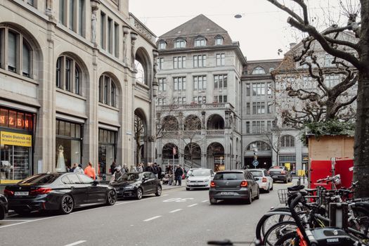 Explore the vibrant street life and historic architecture of Zurich, Switzerland in this captivating photo.