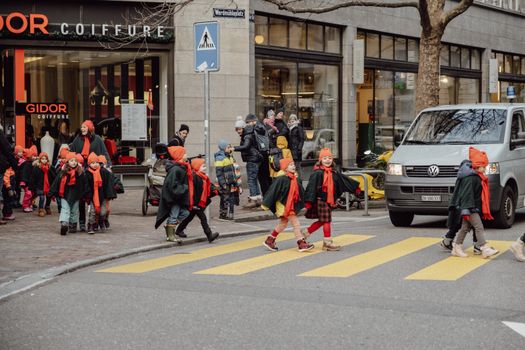 A group of children in costumes cross a street in Zürich, Switzerland.