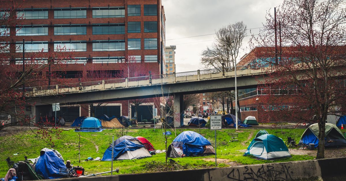 Homeless encampment with tents in downtown Portland under an overpass, capturing social issues.