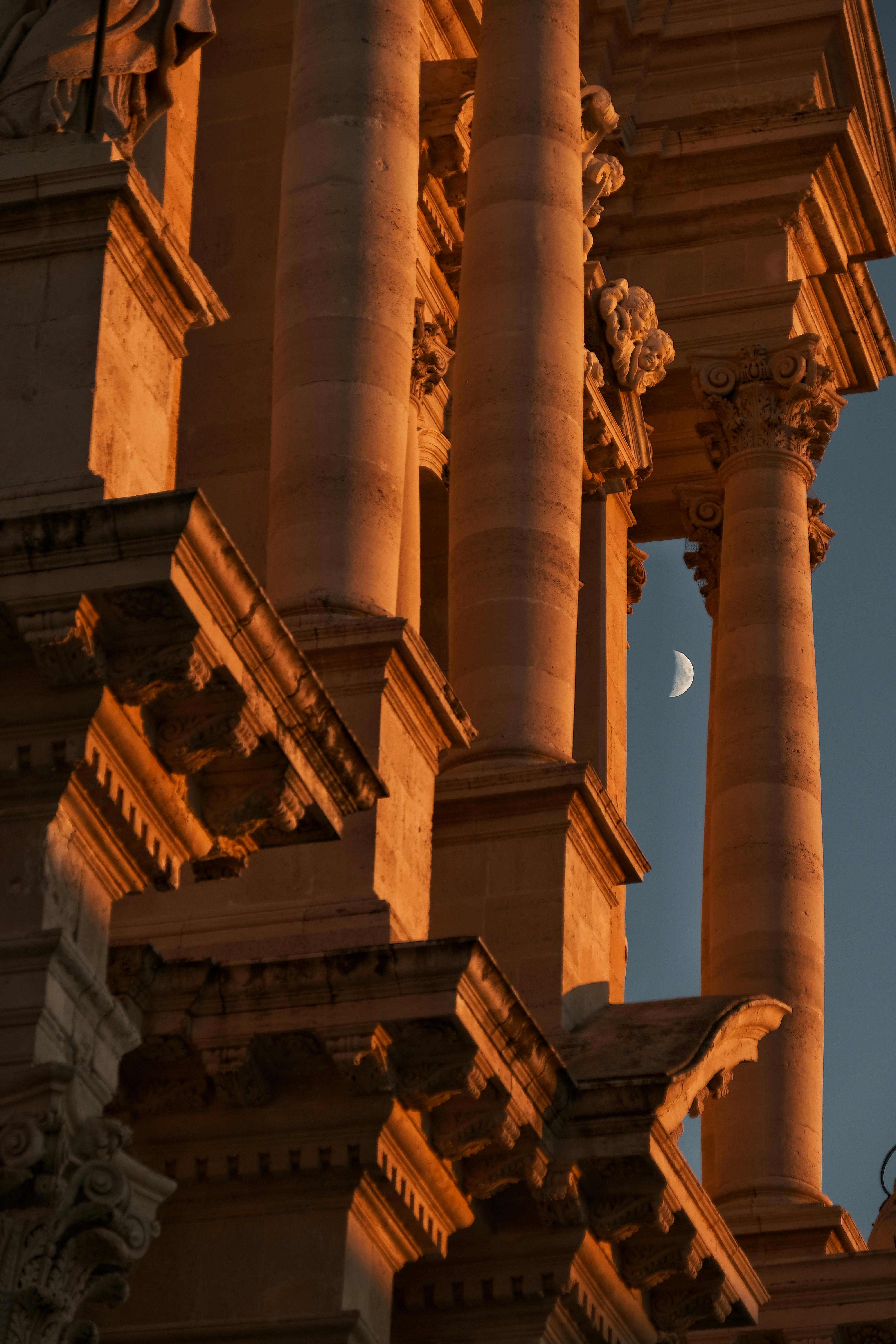 Capture of ancient temple columns in Sicily, Italy with moonlight at sunset.