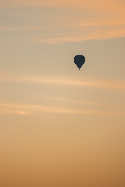 A hot air balloon flying in the sky at sunset