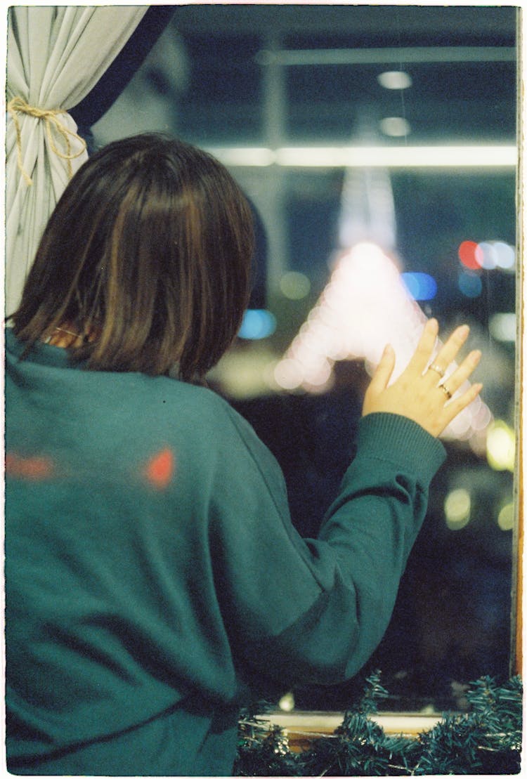 Brunette Woman Looking At Lights Through Window