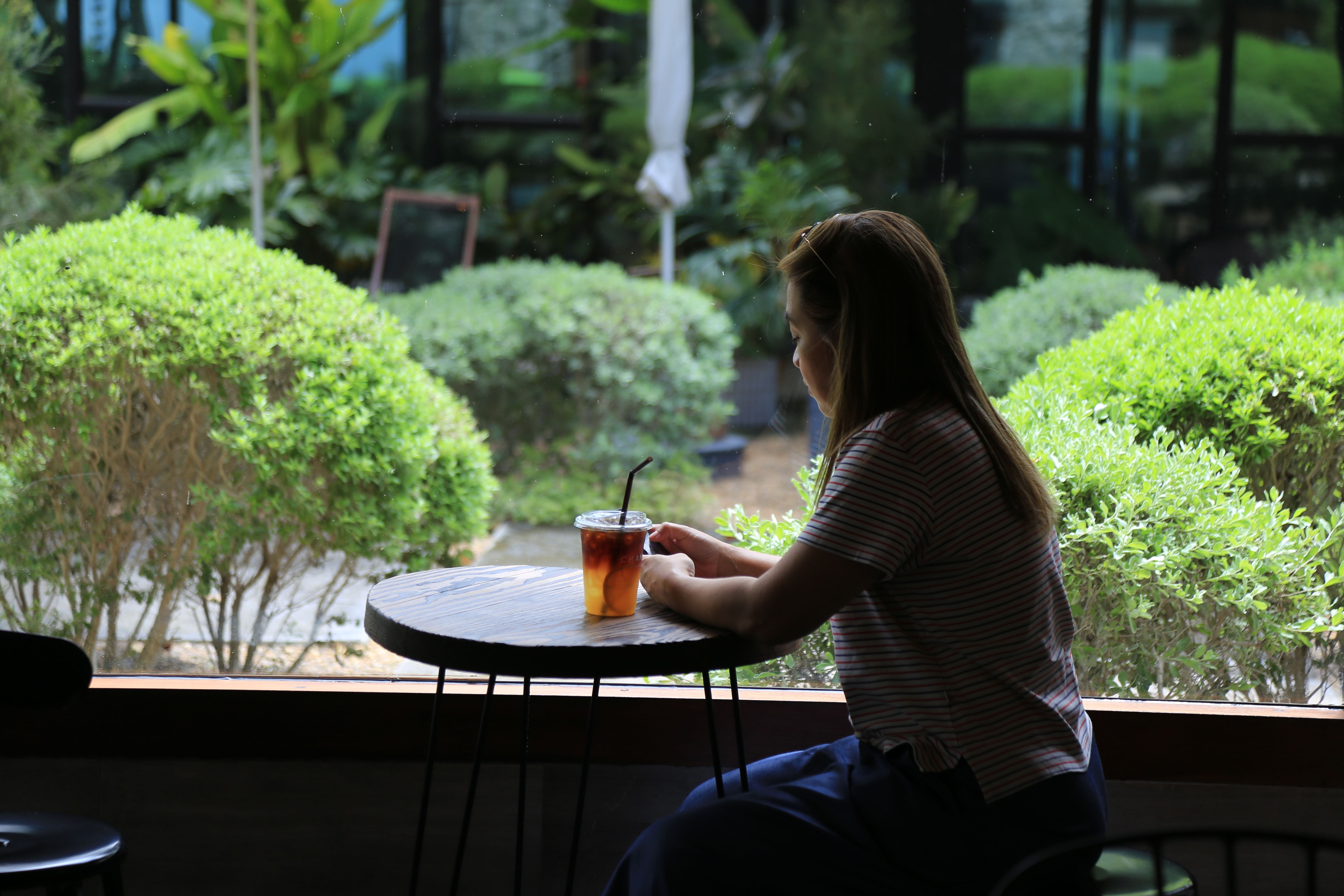 person sitting alone in a coffee shop, looking thoughtful and relaxed