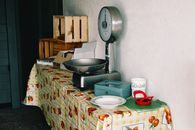 A vintage weighing scale on a table with retro decor and kitchen items.