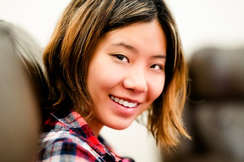 Close up Candid Portrait of Chinese Teen Indoors Seated